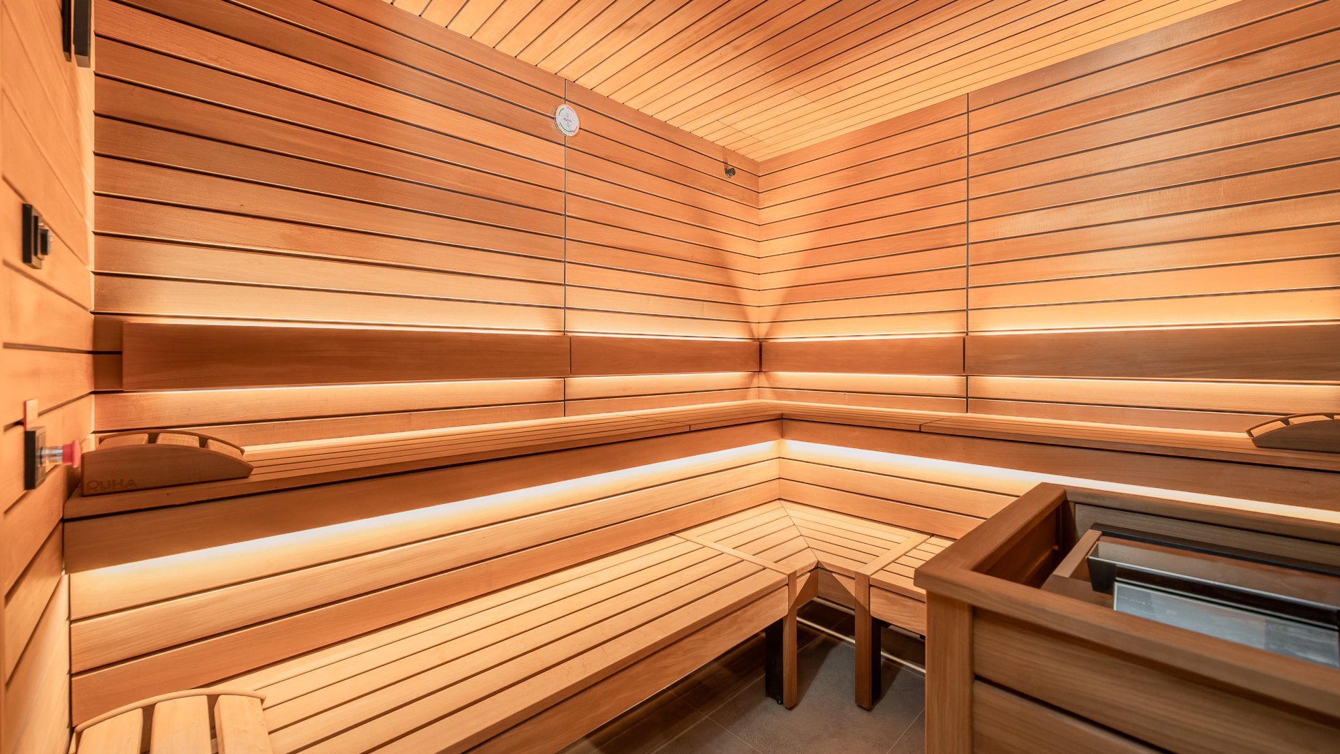 Sauna im neu renovierten Wellnessbereich des Hotel – Entspannung pur am Attersee Angenehm beleuchtete moderne Saune im Wellnessbereich am Attersee, Hotel Aichinger
